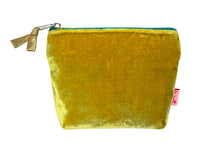 Gold velvet pouch with a pink tag and zip