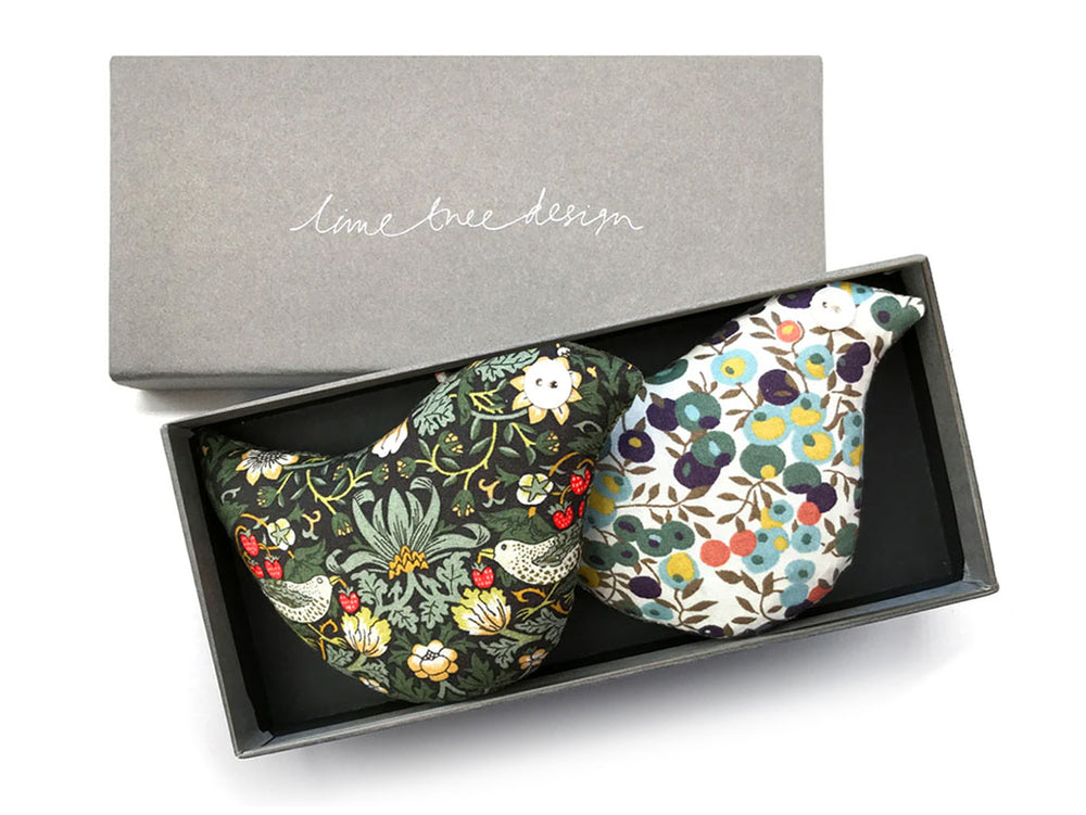 2 lavender bags in the shape of birds in Liberty print fabrics in a grey box