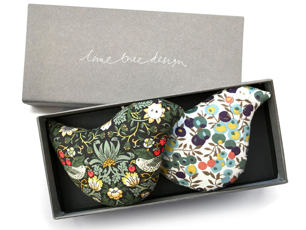 2 lavender bags in the shape of birds in Liberty print fabrics in a grey box