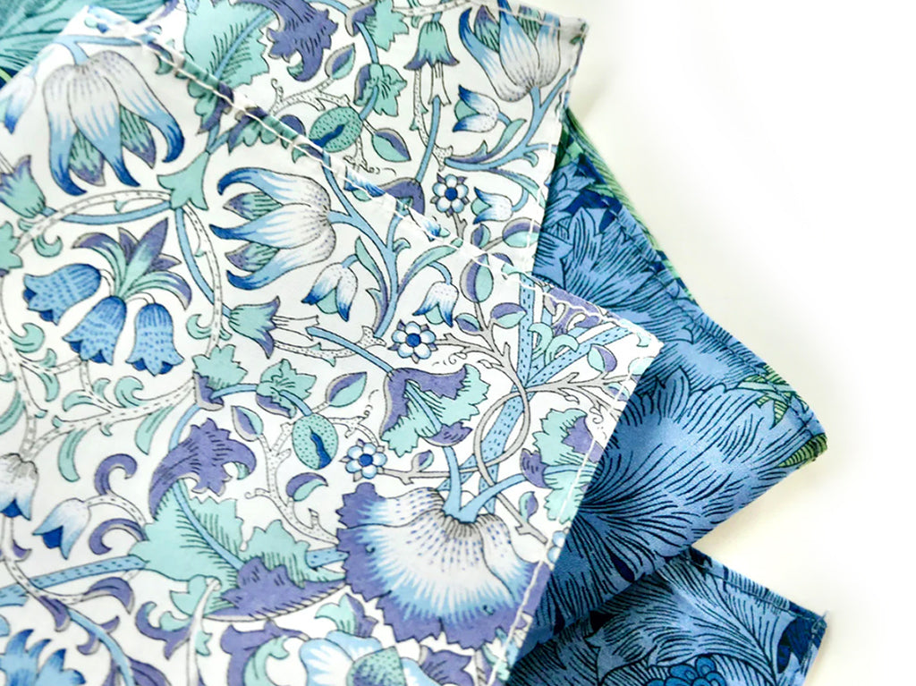 Two pieces of Morris Collection fabric with blue floral patterns in Liberty fabric