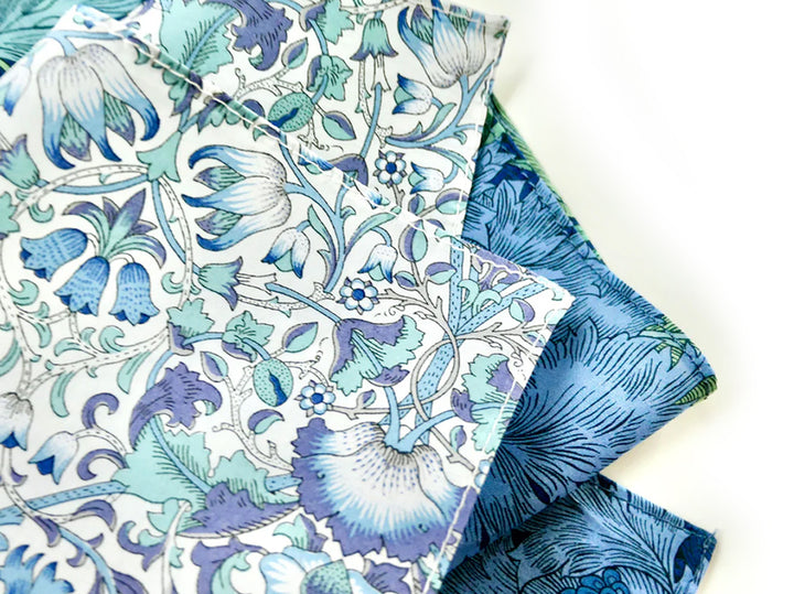 Two pieces of Morris Collection fabric with blue floral patterns in Liberty fabric