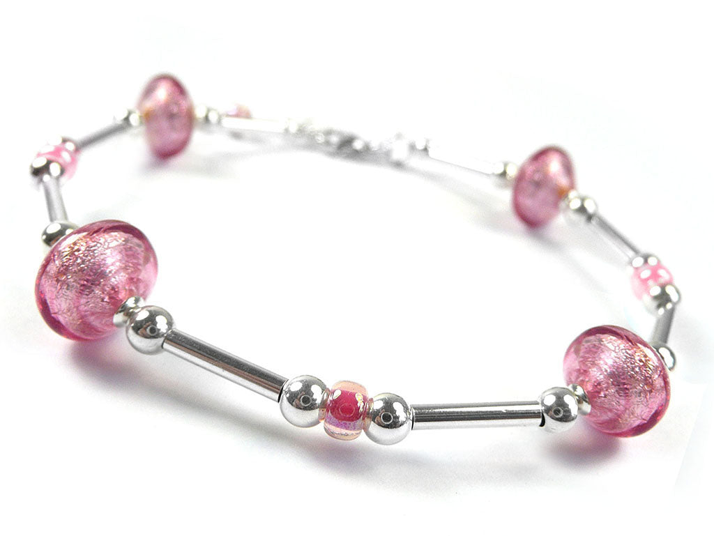 A silver beaded bracelet featuring three Murano pink glass beads and three smaller pink glass beads, displayed on a clean white background.