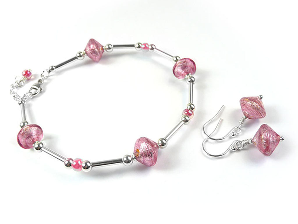 A jewelry set featuring a silver-tone bracelet and matching drop earrings with textured pink glass beads, displayed on a clean white background.