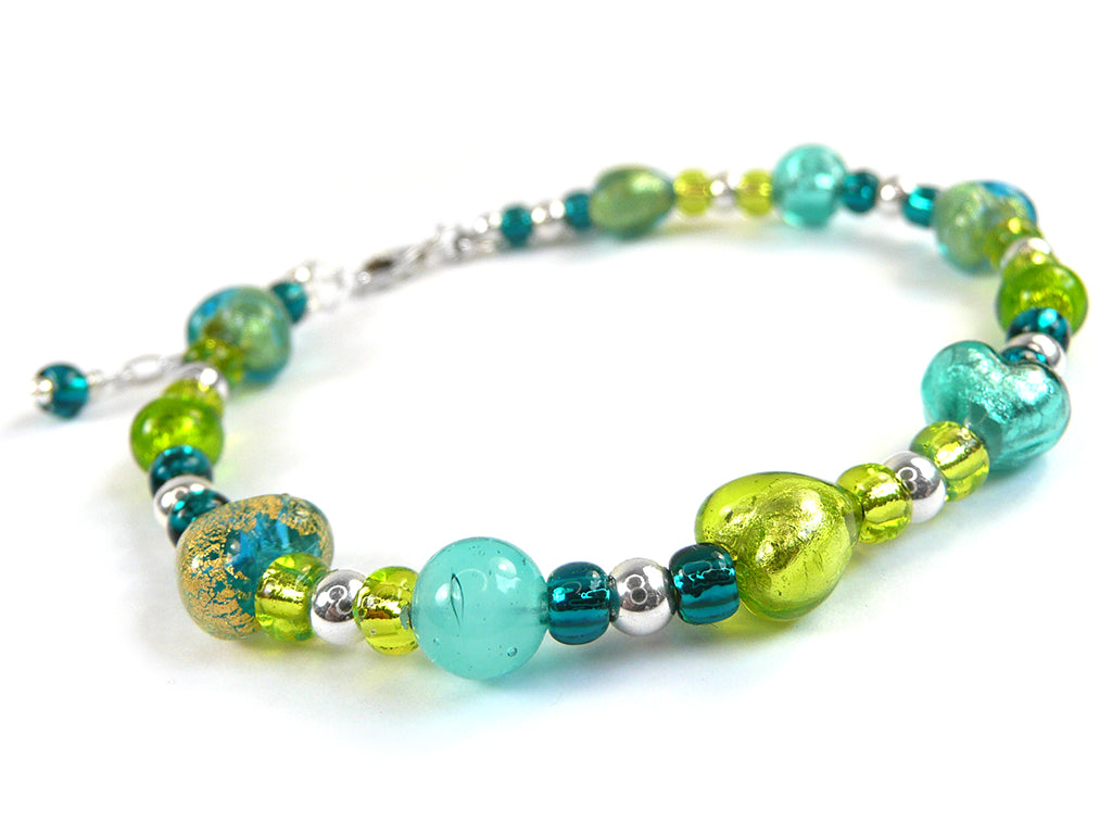 A beaded bracelet featuring a mix of turquoise, lime green, and metallic silver beads, with one prominent textured gold-and-blue glass bead, displayed on a clean white background.