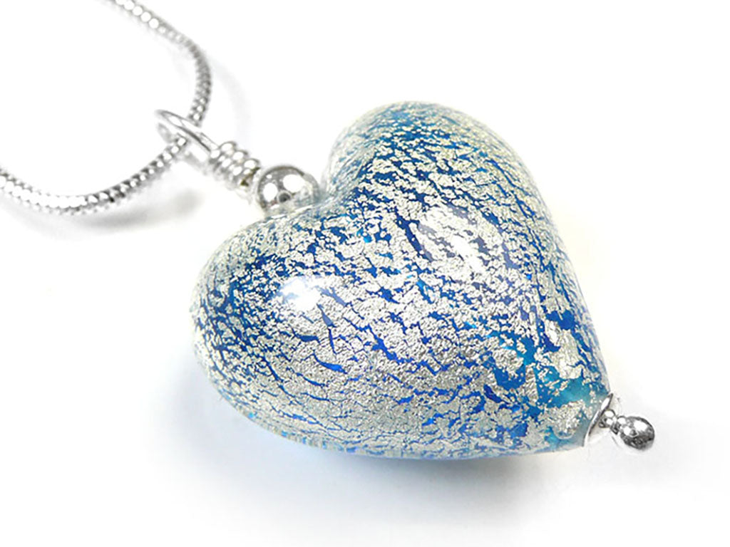 A heart-shaped glass pendant necklace with a textured blue and silver crackled pattern, suspended from a silver chain on a white background.