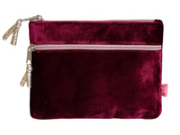 A deep burgundy velvet pouch with two silver-toned zippers and decorative silver zipper pulls, shown against a plain white background.