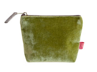 Green velvet pouch with a visible brand tag on a white background