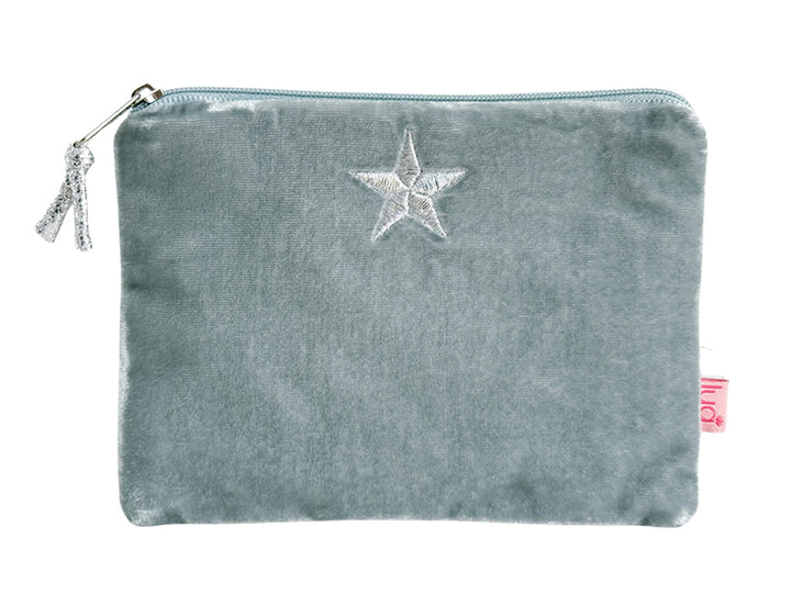 A dusty blue velvet pouch with a silver zipper, a silver embroidered star on the front, and a small pink tag on the side, shown against a plain white background.