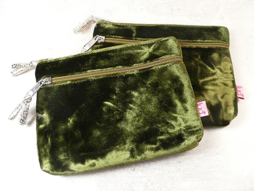 Two olive green velvet zippered pouches with silver-tone hardware and decorative zipper pulls, displayed on a light off-white background.