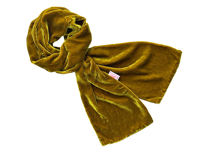 A mustard yellow velvet scarf, styled in a loose knot, shown against a plain white background.