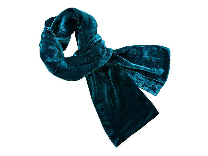 A dark teal velvet scarf, styled in a loose knot with a bow, shown against a solid white background.