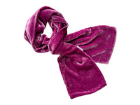 A plush, deep magenta velvet scarf styled in a loose knot on a solid white background.